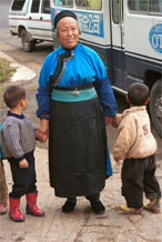 to Jpeg 91K Lao Han woman with children come to see what is happening at the Miao village. Note her apron tied with a knot in front. Lou Jia Zhuang village, Anshun city, Guizhou province 0110A29