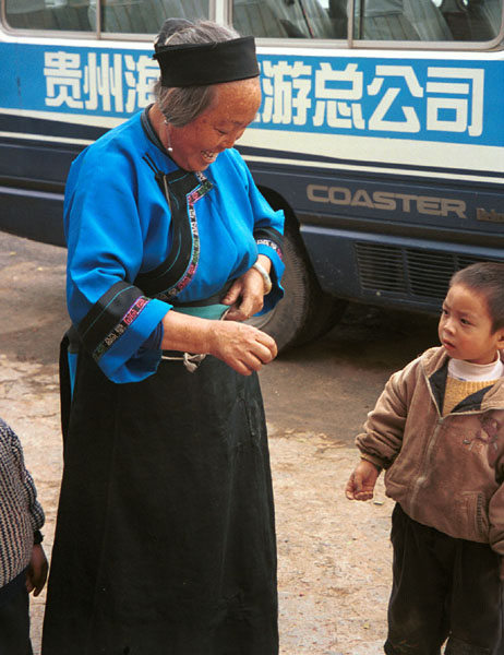 Jpeg 78K Lao Han woman with children who came to see what was happening at the Miao village. She felt that she was not looking smart enough in her apron so took it off to be photographed. Lou Jia Zhuang village, Anshun city, Guizhou province 0110A30 