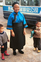 to Jpeg 93K Lao Han woman with children who came to see what was happening at the Miao village. She felt that she was not looking smart enough in her apron so took it off to be photographed (see the small boy on the right of the photo holding the apron. Lou Jia Zhuang village, Anshun city, Guizhou province 0110A31 