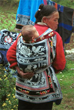 Jpeg 107K Miao woman with baby in waxed (batik) and embroidered baby carrier in Lou Jia Zhuang village, Anshun city, Guizhou province 0110B04