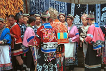 to Jpeg 111K Group of Miao women wearing a mixture of clothing including wax resist (batik) and embroidery. The traditional costume has absorbed styles from other Miao as well as other influences. Note the traditional festival hair styles of some of the women. Lou Jia Zhuang village, Anshun city, Guizhou province 0110B12b