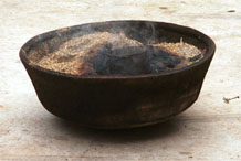 to Jpeg 66K The wax pot heating in a bowl of burning material. The wax heats more steadily and maintains the optimum heat to keep the wax at the correct consistency rather than being on direct flame which overheats the wax. Lou Jia Zhuang village, Anshun city, Guizhou province. 0110B16