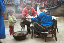 to Jpeg 96K Two Miao women wearing their festival costumes setting up their wax resist (batik). Note in the background the wax resist that they are doing for commercial sale. Lou Jia Zhuang village, Anshun city, Guizhou province 0110B17