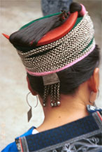 to Jpeg 65K Miao woman showing her traditional hair style (and three la dio (wax knives) tucked into her hair near the right point of her circular comb. Cotton thread and strips of fabric have been used to help secure the coils of hair around the head before the chains are wrapped around. Lou Jia Zhuang village, Anshun city, Guizhou province 0110B27