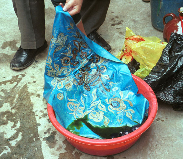 Jpeg 120K Taking the wax resist fabric out of the indigo dye bath after its first dyeing. Note the bright turquoise blue as it emerges before it goes a greenish hue as it oxidises. Lou Jia Zhuang village, Anshun city, Guizhou province 0110B30