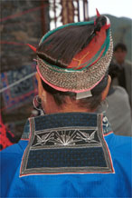 to Jpeg 84K Miao woman showing her traditional hair style. A circular hair comb is used with cotton thread and strips of fabric to help secure the coils of hair around the head before the chains are wrapped around. Note the machine embroidered butterflies on the back of the neck of her jacket. Lou Jia Zhuang village, Anshun city, Guizhou province 0110B35