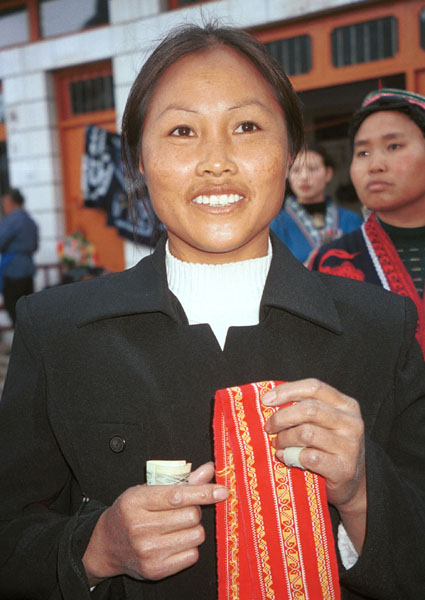 Jpeg 64K Miao woman holding a strip of her hand embroidery which I have just purchased. Lou Jia Zhuang village, Anshun city, Guizhou province. 0110B36