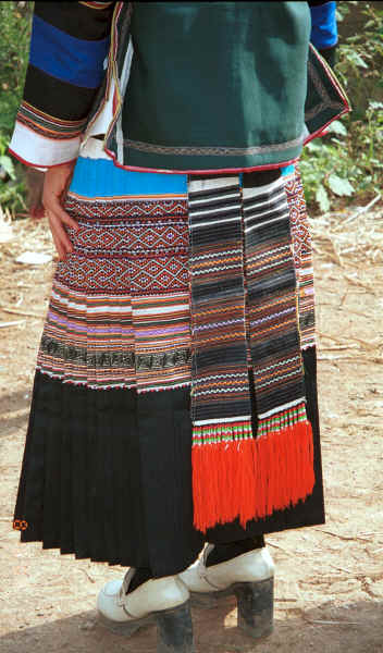 Back view of a Side Comb Miao girl's festival finery showing the hand woven ties of the apron - Pao Ma Cheng village, Teng Jiao township, Xingren country, Guizhou province 0010n12.jpg