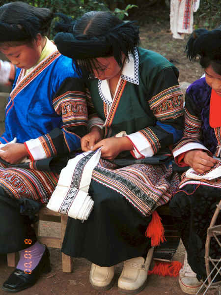 Side Comb Miao girls dressed their festival finery demonstrating embroidery for inserts in the top of their skirts - Pao Ma Cheng village, Teng Jiao township, Xingren country, Guizhou province 0010n26.jpg