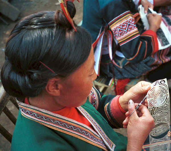 Side Comb Miao married woman finishing cutting a paper cut for embroidery - Pao Ma Cheng village, Teng Jiao township, Xingren country, Guizhou province. 0010n28.jpg