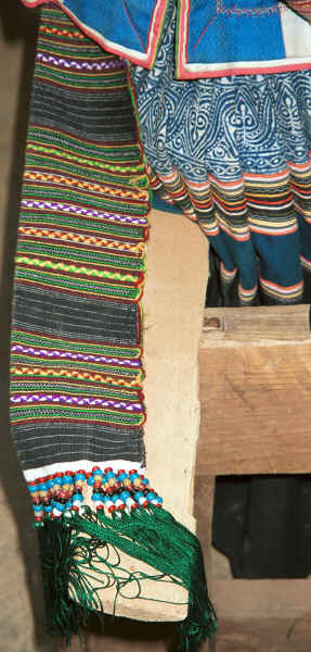 Close up of apron ties of weaver working on weaving such an apron - Side Comb Miao - Pao Ma Cheng village, Teng Jiao township, Xingren country, Guizhou province 0010n36.jpg