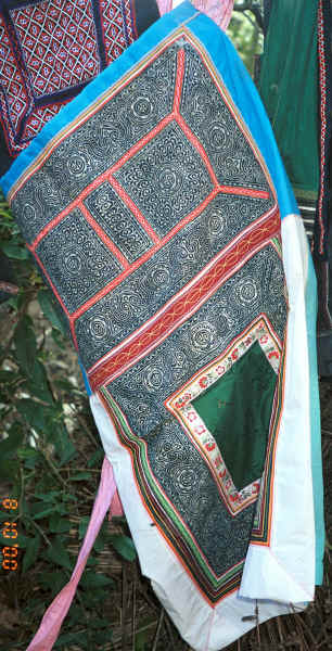 Side Comb Miao baby carrier decorated mainly with batik.  Note that the batik design is very similar to the swirls favoured in the cut out embroidery - Pao Ma Cheng village, Teng Jiao township, Xingren country, Guizhou province 0010o09.jpg