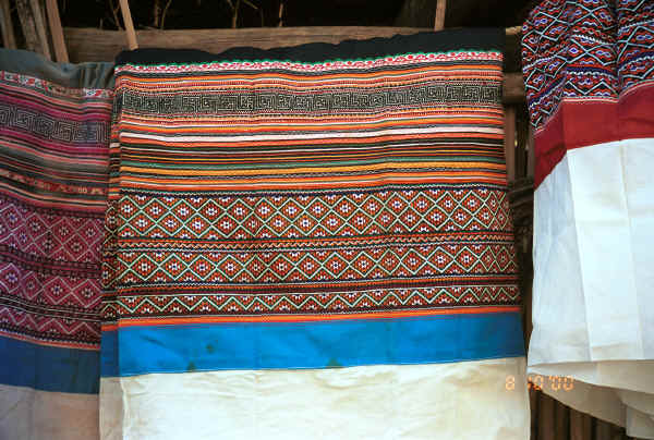 Side Comb Miao skirts hanging out to show the ornately embroidered tops - note that they are all embroidery and rather than batik - Pao Ma Cheng village, Teng Jiao township, Xingren country, Guizhou province 0010o13.jpg