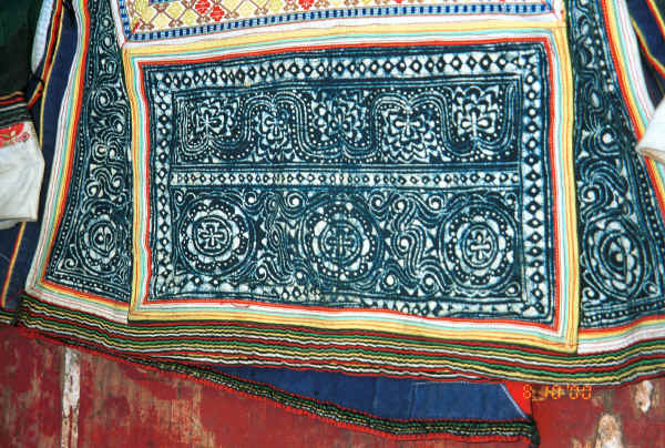 Side Comb Miao woman's jacket showing batik inserts and appliqued strip edgings.  These edgings have been applied by hand as can be seen from the back of the jacket showing at the bottom.  Pao Ma Cheng village, Teng Jiao township, Xingren country, Guizhou province. 0010o16.jpg