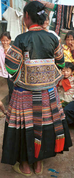 Side Comb Miao girl showing how her festival costume is assembled - and conscious that her hairstyle and footwear are wrong! Pao Ma Cheng village, Teng Jiao township, Xingren country, Guizhou province 0010o18.jpg