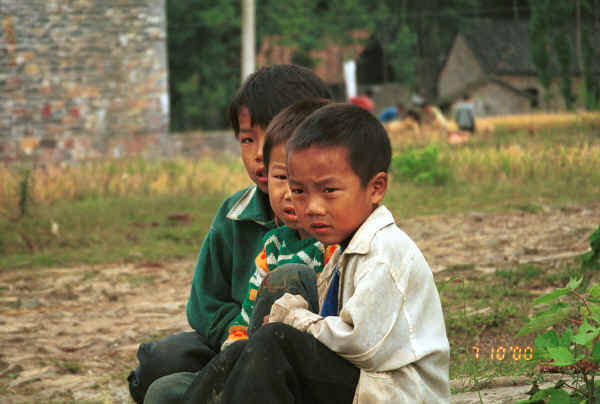 Young Miao boys at the entrance to the village against the stone houses and rice harvest - Sha Jiao village, Wan Teng township, Xingyi metropolitan area, Guizhou province 0010l09.jpg