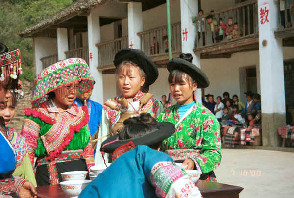 Organising the welcome drinks watched from the school by children and other villagers - Sha Jiao village, Wan Teng township, Xingyi metropolitan area, Guizhou province 0010l33.jpg