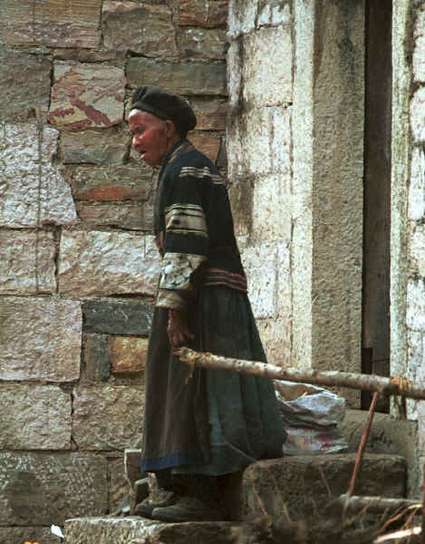 Old Bouyei lady coming out of the doorway of her house - Shitou village, Huanggousu township, Zhen Nin county, Guizhou province 0010t37A.jpg