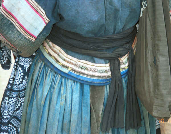 Detail of the back of a jacket with an apron tied around it worn by an old Bouyei textile seller - Shitou village, Huanggousu township, Zhen Nin county, Guizhou province 0010u18.jpg