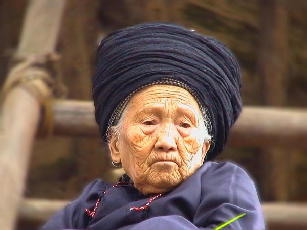 Jpeg 37K An old woman, wearing her turban which may be between 6-10 metres in length, watching the festivities in a Miao village in Songtao Miao Autonomous County, Tongren Prefecture, eastern Guizhou Province.