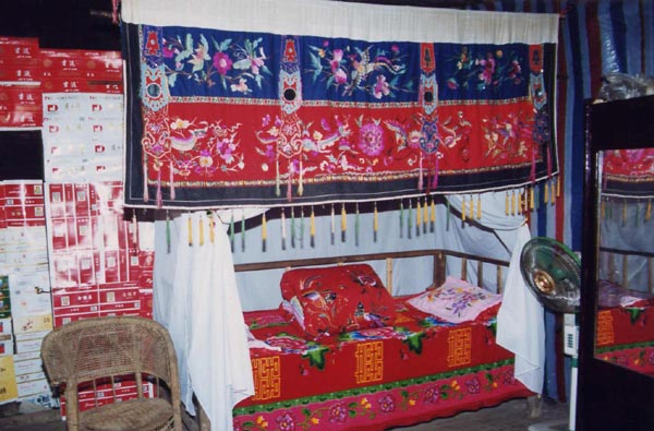 Jpeg 63K Display of embroidery on a bed possibly for a wedding in Songtao Miao Autonomous County, Tongren Prefecture, eastern Guizhou Province.