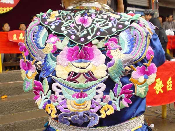 Jpeg 54K Close up of the back view of a Miao girl at a festival in a village in Songtao Miao Autonomous County, Tongren Prefecture, eastern Guizhou Province. Note the bold embroidery collar covering the back of the blouse.