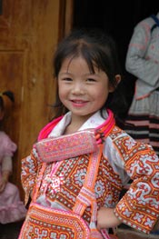 to Jpeg 59K Young Long Horned Miao girl showing off her beautifully embroidered festival costume.