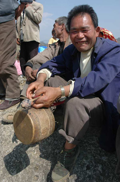 Jpeg 57K White Miao man with small drum at the Dance Flower festival near Dafang in April 2007