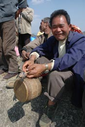 Jpeg 57K White Miao man with small drum at the Dance Flower festival near Dafang in April 2007
