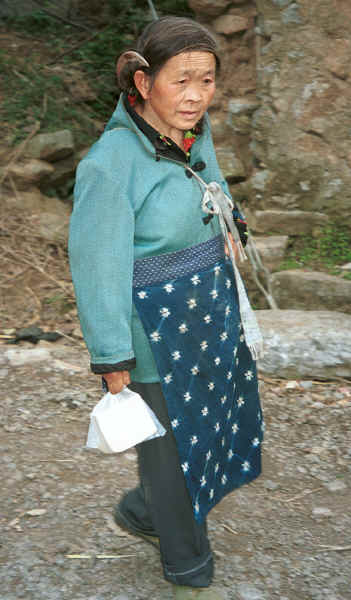 Side Comb Miao woman walking through a village beside the road - after leaving Hou Chang township for Puding, Guizhou 0010z06.jpg