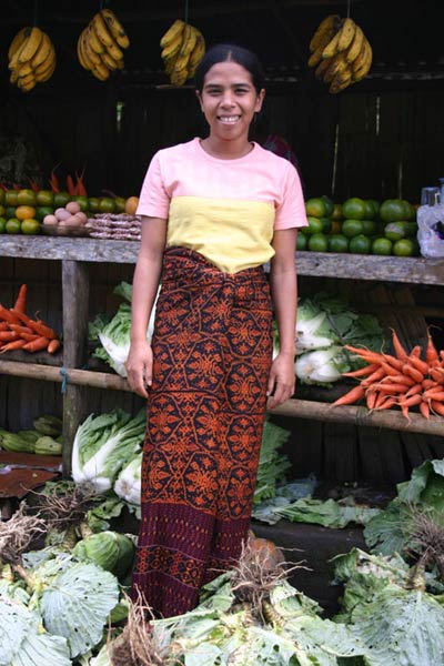 53K Jpeg 0161 Roadside fruitseller outside Maumere, Flores (2004). Her sarong reflects the patola influence. (Patola - a double ikat textile originally woven in southern India and traded into Indonesia.)