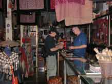 to Jpeg 57K  Bucklee Bell with a customer in his side of the gallery 'Kesorn Arts' which he runs with his wife Kesorn Bell in Chiang Mai 3397