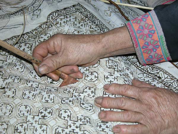 Jpeg 57K White Hmong woman in Ban Pha-nok-kok village waxing cloth before dyeing.  3437