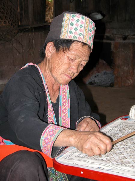 Jpeg 45K White Hmong woman in Ban Pha-nok-kok village waxing cloth before dyeing.  3441