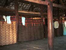 12. to Jpeg 34K Curtains separating off the sleeping areas from each other and from the living area in a Black Thai (Tai Dam) House.in Dien Bien Phu, Lai Chau Province, Vietnam. The curtains show various styles of decorative heading bands. The main fabric in the curtain second from the left is probably a hand-woven cotton plaid fabric. October 1995. 