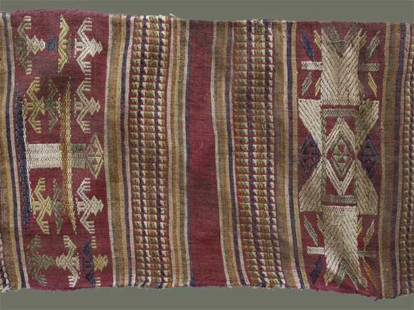 Jpeg 59K From Xam Tai, detail of an unusual mosquito net border (now in the collection of Pamela Cross) which is a lovely shade of brown, with accents of purple, gold and yellow. It is unusual because of the design motifs: elongated, stylized star motifs with arrows; also present in a few places are stylized animal motifs and figures with up-raised hands. One end is a dark red (as shown in the detail above) rather than brown. It is all handspun cotton (or perhaps fine hemp?) with cotton and some silk supplementary weft. Condition is very good, tho there are soiled areas throughout. Size: 274" (22'-10") x 9.5" 