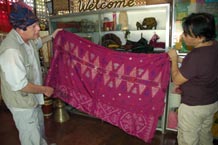 to Jpg 63K Nick Fielding examining an old silk malong at the Aljamelah Inaul Weaving and Sewing Center - Mindanao, 2007 