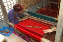 to Jpg 49K A weaver points out details in the heddles of a loom at the Aljamelah Inaul Weaving and Sewing Center - Mindanao, 2007