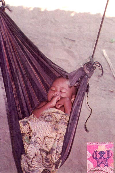 ss23 Jpeg 52K Sleeping infant, Southern Thailand, ethnic Malay village near Ranong. The batik coverlet, as well as the sarongs wore by the women in the prior photos, are simply cotton lengths with printed batik designs, rather than actual batik pieces. These sarongs are ubiquitous throughout SEAsia.