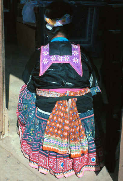 Back view of a Blue Hmong woman showing collar, sash and skirt 8812L00A