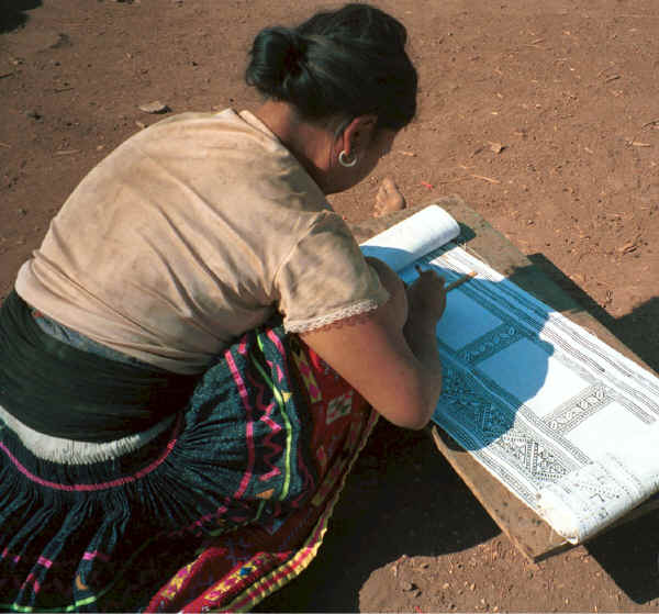 Blue Hmong woman applying wax to a piece of cotton fabric for a skirt (before dyeing with indigo) 8812N30A