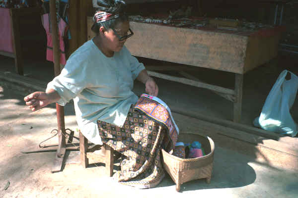 Blue Hmong woman sewing on triangles to bottom border for a skirt in a village on Doi Suthep above Chiang Mai 8812l03