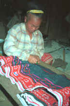 to Jpeg 32K Blue Hmong woman drawing up a skirt into gathers in a village on Doi Chiang Dao on the road from Chiang Mai to Fang 8812n29