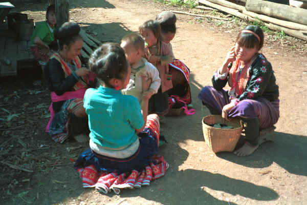 Blue Hmong women and children chatting and sewing in a village along the road from Chiang Mai to Fang 8812n31