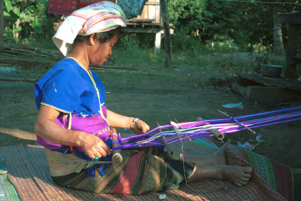 Sgaw Karen woman weaving at her backstrap loom dressed in a traditional hand-woven blouse 8812p01.jpg
