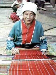 15K Jpeg Back strap loom in use, Chiang Mai, Thailand, Silver Palaung village. The Silver Palaung woman is weaving a length of fabric for the traditional tube skirt.