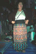 to Jpeg 49K A Yao woman in the Chiang Mai night market holding up a trouser panel for a pair of women's trousers which she had embroidered and which is now in my textile collection 8812m13.jpg