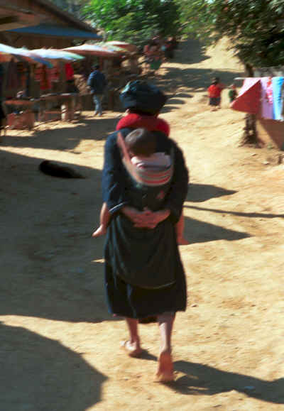 A grandmother carrying her grandchild in a baby carrier on her back in a village in the hills around Chiang Rai 8812q28.jpg