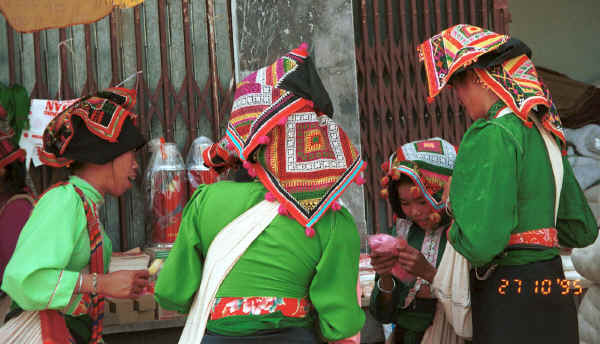 Jpeg 33K Black Thai women examining goods for sale in Ban Vay market on the road from Son La to Dien Bien Phu in Son La Province showing off their embroidered head cloths 9510C21.JPG