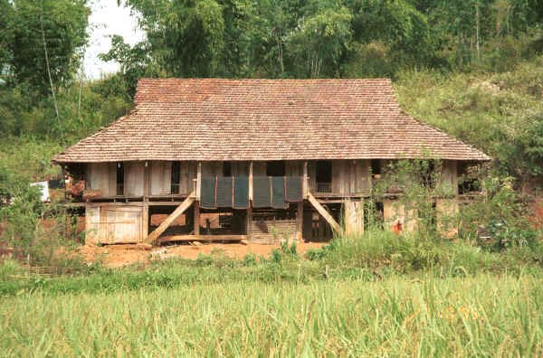 Jpeg 42K Black Thai house with six mattresses hanging out air.  Note the coverings in indigo cloth and edges with hand woven supplementary weft cloth on the road north leaving Son La, Son La Province. 9510C27.JPG